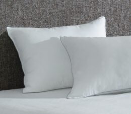 Two AllerEase pillows shown on a bed. These antimicrobial pillows also have a temperature balancing, soft top layer.