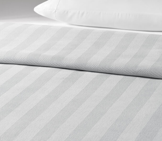 The Chenille Herringbone bedspread is shown here on a bed in the Lunar colorway.