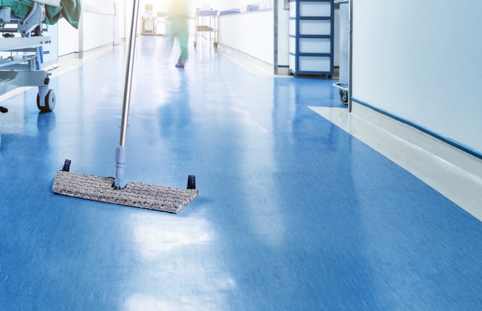A pre-prepared mop being used to clean a hospital floor.
